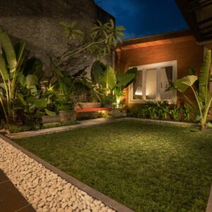 A well designed courtyard with lush grass and new rocks.