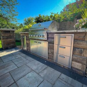 A gorgeous outdoor kitchen area with a grill.