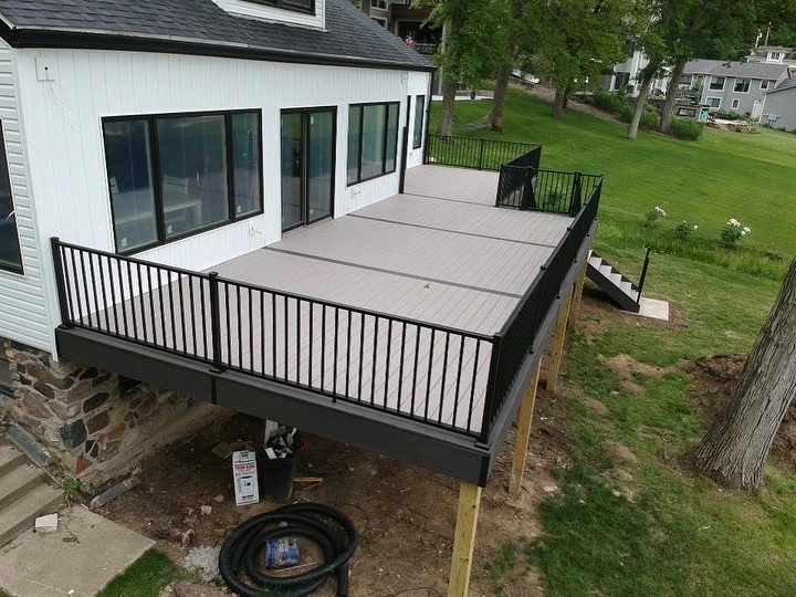 curbscapefw hardscaping huntertown in 1 - Curbscapes Outdoors Elevated deck construction with black railings and composite boards attached to a white house.