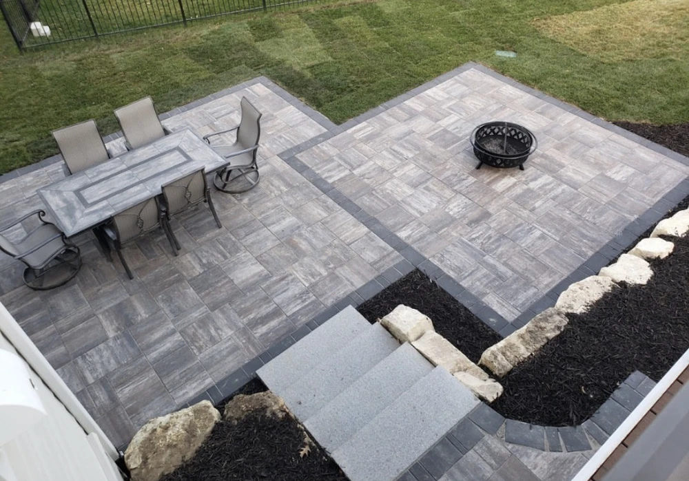 Curbscapes Outdoors patios fort wayne in - Curbscapes Outdoors Gray pavers form a two-zone patio with a dining set. fire pit. black mulch. and stone-edged steps.