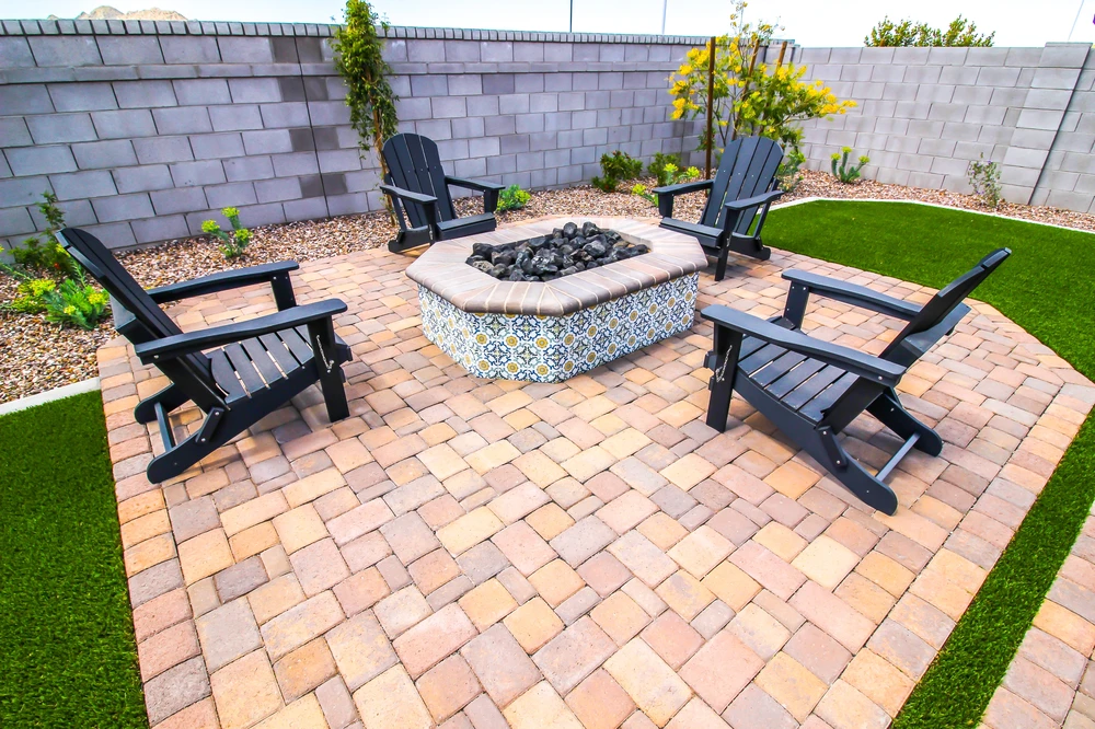 Curbscapes Outdoors pavers huntertown in - Curbscapes Outdoors Tan pavers form a cozy fire pit patio with black chairs. patterned tile. and bright green turf strips.